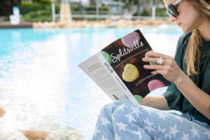 This is an image of a woman reading Splitsville the Book via the poolside.